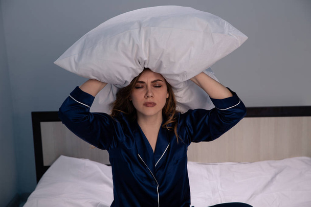 Vystresovaná žena v posteli držící polštář na ruce. - Fotografie, Obrázek