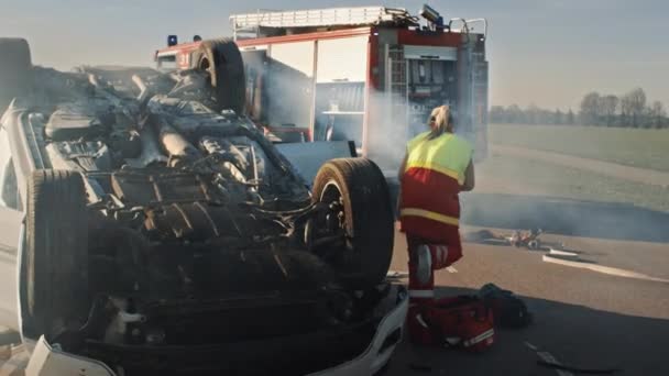Rescue Team of Firefighters and Paramedics Work on a Terrible Car Crash Traffic Accident Scene. Preparing Equipment, Stretches, First Aid. Saving Injured and Trapped People from the Burning Vehicle - Footage, Video