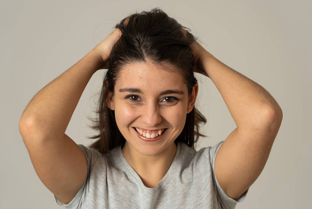 Close up portrait of pretty young latin woman with happy face and beautiful smile. Messing with her hair and staring at the camera. Copy space. In People, positive facial expressions concept. - Photo, Image