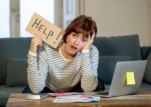 Portrait of worried young woman feeling stressed and desperate asking for help in paying bills, debts, tax expenses and accounting home finances with laptop. In online banking and financial problems. - Foto, Imagem