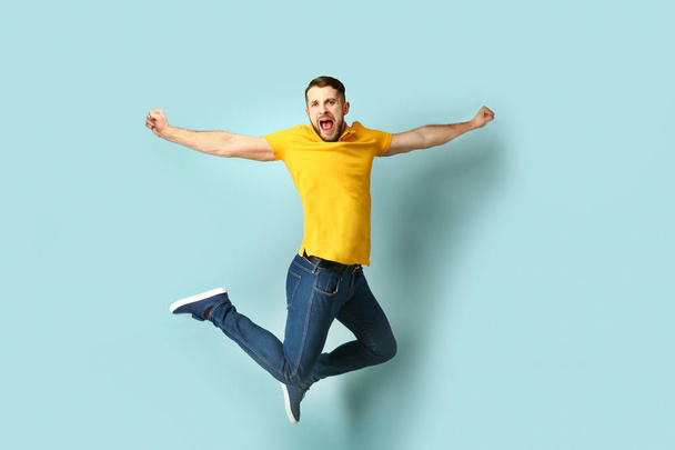 Screaming jumping man on color background - Фото, зображення