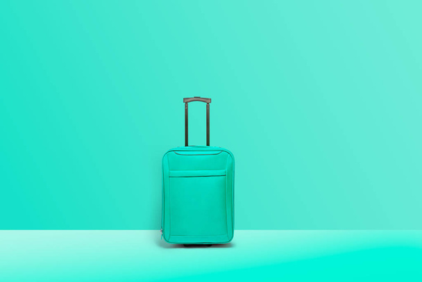 Turquoise koffer staande. Concept van toerisme en reizen - Foto, afbeelding