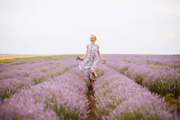 Foto van knappe jonge vrouw, plezier hebben in een Lavendel veld - Foto, afbeelding
