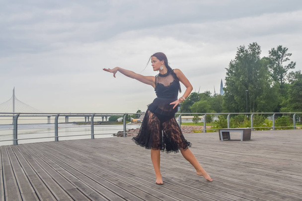 the waterfront girl in a black dress dancing - 写真・画像