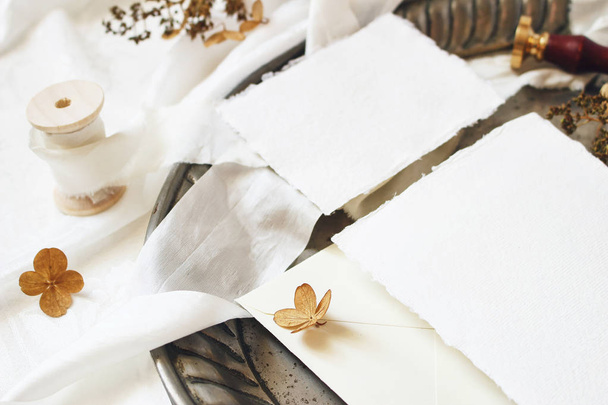 Winter, fall styled wedding, birthday table composition. Stationery mockup scene. Closeup of greeting cards, envelope, dry hydrangea flowers and ribbon on old vintage silver tray. Selective focus. - Valokuva, kuva