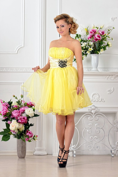 Beautiful woman in yellow dress in luxury studio. - Fotoğraf, Görsel