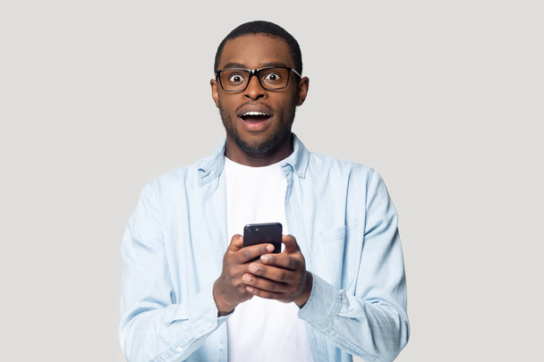 Surprised black male excited by message on smartphone - Photo, Image