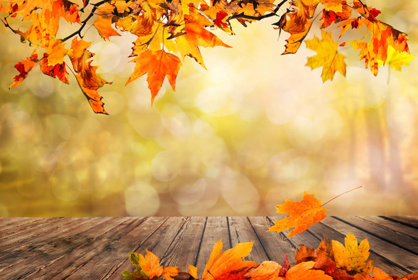 Holztisch mit orangefarbenen Blättern Herbst Hintergrund - Foto, Bild