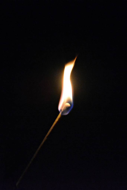Una singola partita brucia molto lentamente al buio della notte e fuma leggermente verso l'alto - La fiamma calda di una partita illumina la notte
  - Foto, immagini