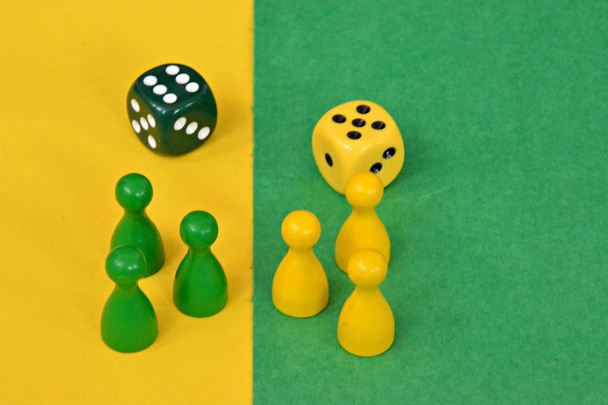 ボードゲームの木製のゲームキャラクターのチームは、お互いに直面し、それぞれの反対の色の背景で迎えられています  - 写真・画像