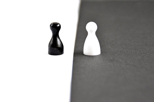 Un peón negro se levanta frente a un fondo blanco y viceversa - concepto con fuertes contrastes como símbolo de diferencias e igualdad, así como ying y yang
 - Foto, Imagen