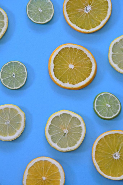 Zitrusfrüchte wie Orange, Limette und Zitronen auf einfarbigem Hintergrund - geschnittene Zitronen, Limetten und Orangen mit farbigem Hintergrund - Foto, Bild