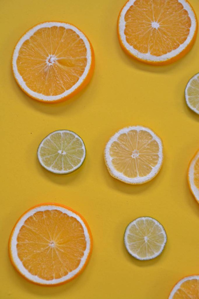 εσπεριδοειδή όπως πορτοκαλί, λάιμ και λεμόνια σε μονόχρωμη φόντο-φέτες λεμόνια, λάιμ και πορτοκάλια με χρωματιστό φόντο - Φωτογραφία, εικόνα