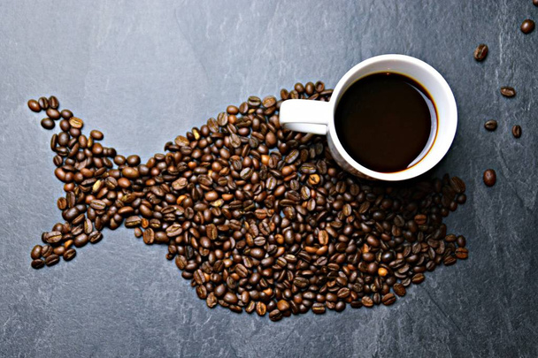 Les grains de café sur fond noir forment la silhouette d'une baleine et deux tasses de café forment leurs yeux - concept avec le café et la baleine
  - Photo, image