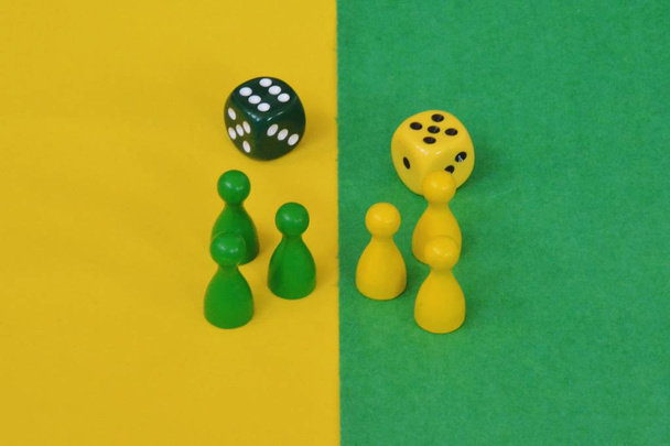 team van houten spelkarakters van een bordspel geconfronteerd met elkaar en worden begroet door de respectieve tegengesteld gekleurde achtergrond  - Foto, afbeelding