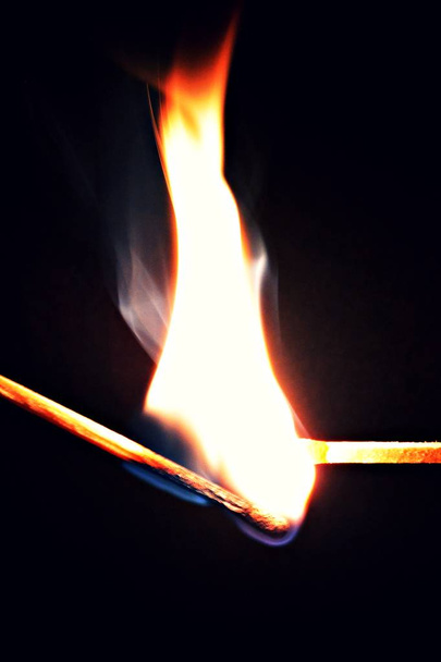 Горящий спичка зажигает нетронутый матч на темном фоне - концепция разжигания страсти через прохождение пылающего пламени
  - Фото, изображение