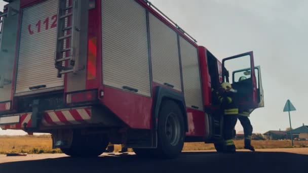 Mentőcsapat tűzoltók érkezés az autóbalesetben közlekedési baleset jelenet saját Fire Engine. Tűzoltók fogd a felszerelés, előkészíti Tűzoltó tömlők és sebességváltó a Fire Truck, Rush, hogy segítsen sérült emberek - Felvétel, videó
