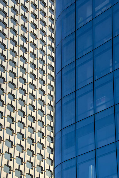 Abstract vertical background with office buildings facades overlapping each other. Reflections in windows, business and finance background with copy space, perfect for text - Φωτογραφία, εικόνα