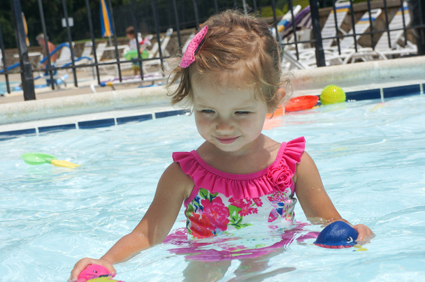 Cute baby girl is having fun in the pool - Photo, Image