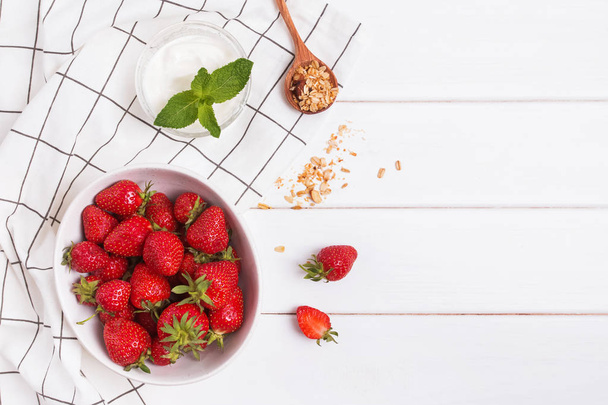 Νόστιμες φρέσκες φράουλες, γιαούρτι και Γκρανόλα στο κουτάλι. - Φωτογραφία, εικόνα