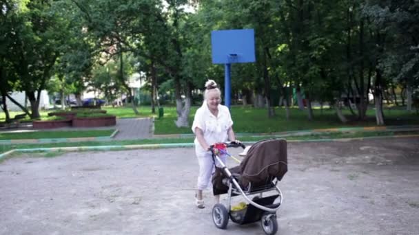 Abuela caminando con su nieto en un cochecito de bebé
 - Imágenes, Vídeo