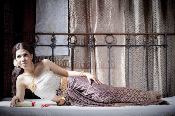 Gorgeous asian woman in thai dress lying on bed - Zdjęcie, obraz