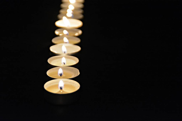 concept with the warm light of the candles in the dark as hope for a warmer and brighter time  - Photo, Image