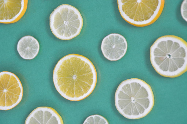 Zitrusfrüchte wie Orange, Limette und Zitronen auf einfarbigem Hintergrund - geschnittene Zitronen, Limetten und Orangen mit farbigem Hintergrund - Foto, Bild