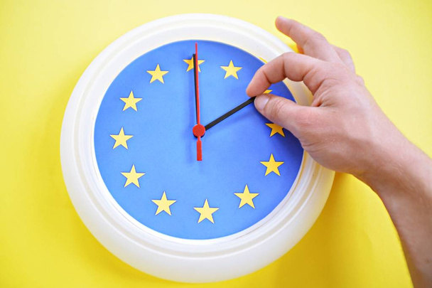 Yakın çekim-bir el, AB bayrağının renkleri ile bir saat devam ediyor-Avrupa 'da zaman değişikliği ve kaldırılmasının üzerine yapılan oylamanın yanı sıra - Fotoğraf, Görsel