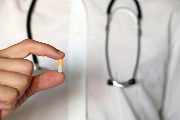 Fogamzásgátló tabletta orvos, férfi kéz gyógyszeres kapszula közeli. Férfi tabletta, fogalma gyógyszerész, gyógyszerek, diéta pirula, antibiotikum vagy vitamin - Fotó, kép