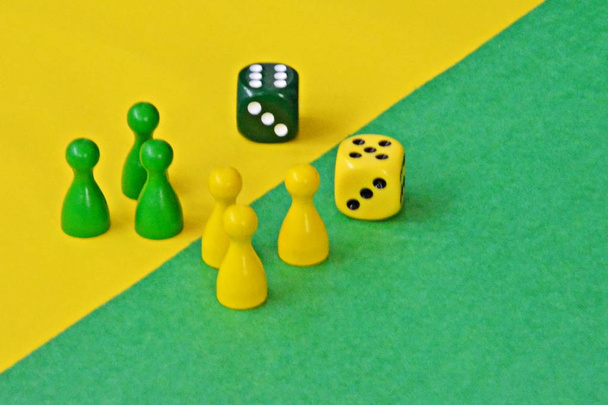 ボードゲームの木製のゲームキャラクターのチームは、お互いに直面し、それぞれの反対の色の背景で迎えられています  - 写真・画像