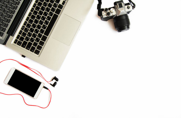 Plochý pohled na obraz fotografa pracovního prostoru s laptopem, fotografické vybavení a telefon s telefonem na bílém podkladu. Místo pro text - Fotografie, Obrázek