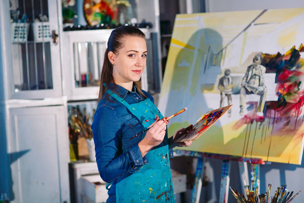 Beautiful Girl in a Painting Studio draws a picture. - Photo, Image