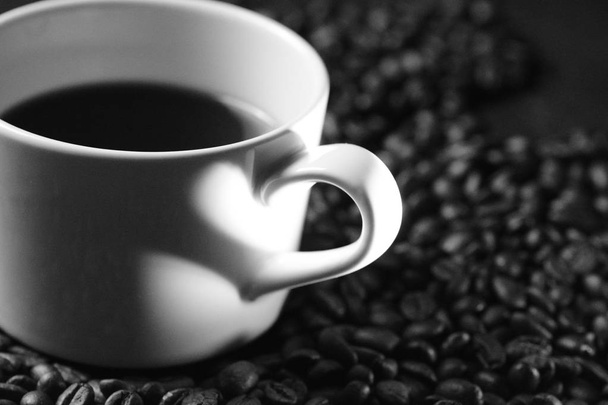 Minimalistinen konsepti, jossa varjo kuvaa rakkautta kahviin kahvan kahvan varjo ja joka seisoo kahvipapujen päällä näyttää sydämeltä valon varjossa
  - Valokuva, kuva