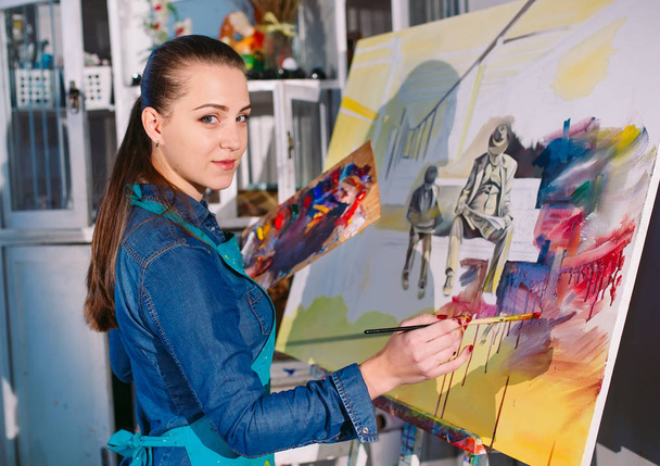 Beautiful Girl in a Painting Studio draws a picture. - Фото, зображення