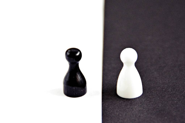Czarny Pawn stoi przed białym tle i vice versa-koncepcja z silnym kontrastów jako symbol różnic i równości, a także Ying i Yang - Zdjęcie, obraz