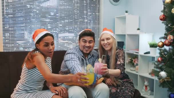 Três amigos sorridentes em chapéus de Papai Noel fazendo vivas com coquetéis
 - Filmagem, Vídeo