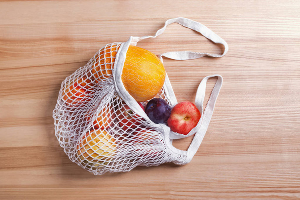 Different summer fruits in reusable shopping bag on the wooden table - Valokuva, kuva