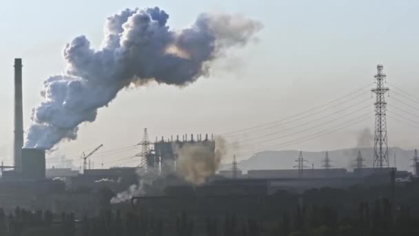 煙の積み重ねの空から蒸気を吹き飛ばす。鉄鋼工場の煙突を吸う。クローズアップ。日の出汚染環境における鉄鋼工場の煙突。大気汚染の概念.  - 映像、動画