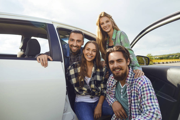 Group of people standing next travel in the car on road. - Foto, Imagen