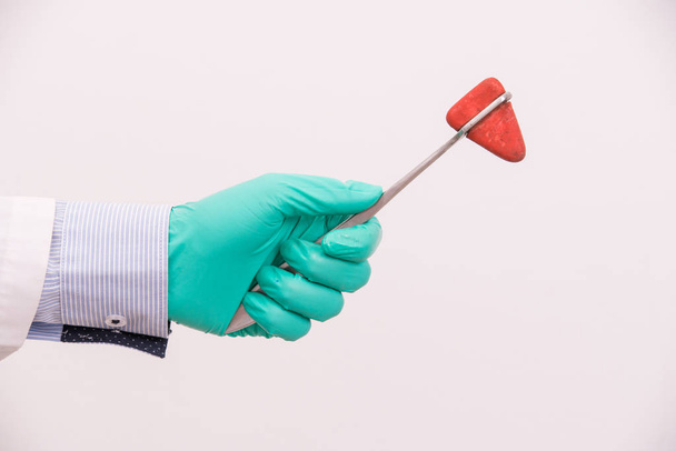 γιατρός χέρι κρατώντας ιατρικό εργαλείο, σφυρί μαλακία γόνατο - Φωτογραφία, εικόνα