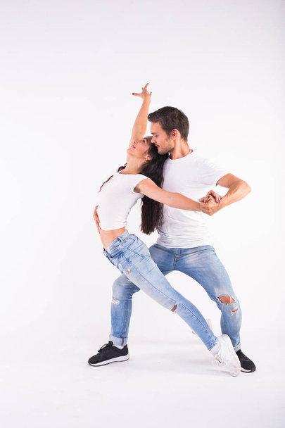 若いカップルは社会のラテン ダンス バチャータ、メレンゲ、サルサを踊るします。白い背景の上の 2 つのエレガントなポーズ - 写真・画像