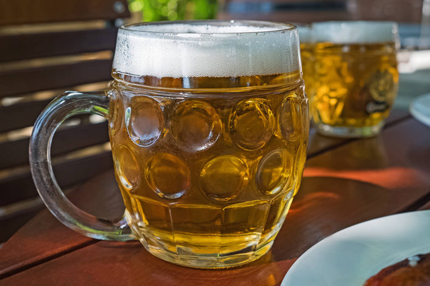 Traditional beer mug with light lager beer in a street caffee - Фото, изображение