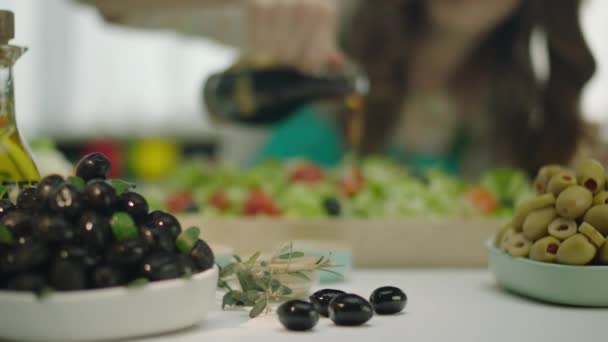 トマト、ニンジン、キャベツをオリーブオイルで混ぜ合わせたサラダを注ぐ女性  - 映像、動画