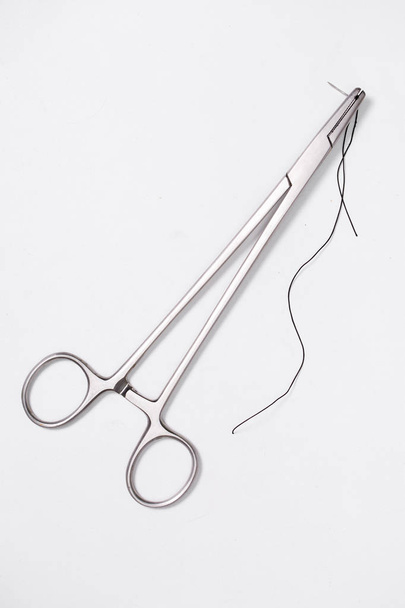 хирургический инструмент на белом фоне, держатель иглы
 - Фото, изображение