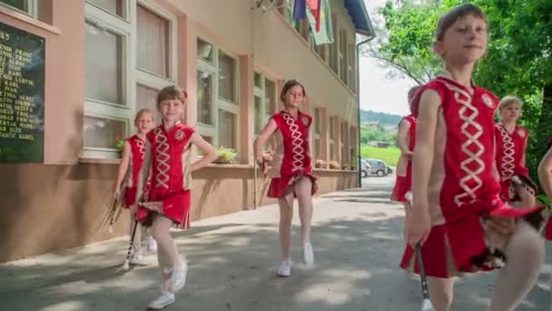 Dziewczęta noszą czerwone stroje i ćwiczy z ich majorette laski. Odbywa się to w stoczni szkolnej. - Materiał filmowy, wideo
