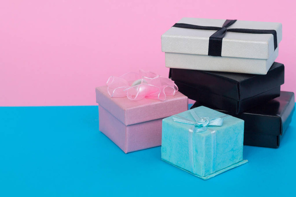dárkové krabice se stuhami a luky izolované na růžovém a modrém pozadí - Fotografie, Obrázek