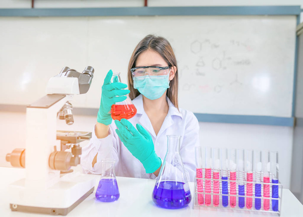 Женщина-врач или химик, работающий с микроскопом в лаборатории r
 - Фото, изображение