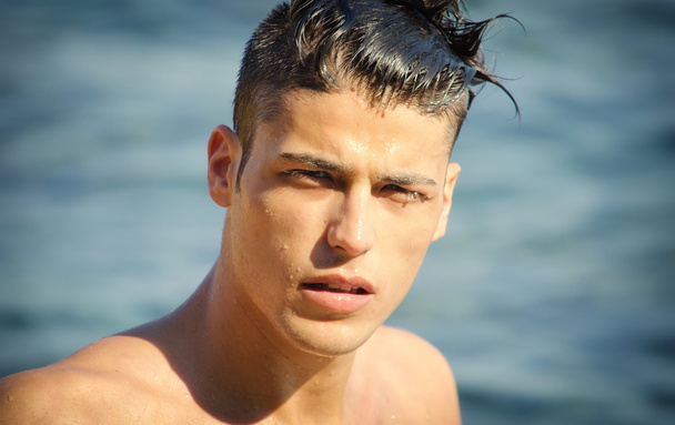 Handsome young man getting out of water with wet hair - Zdjęcie, obraz