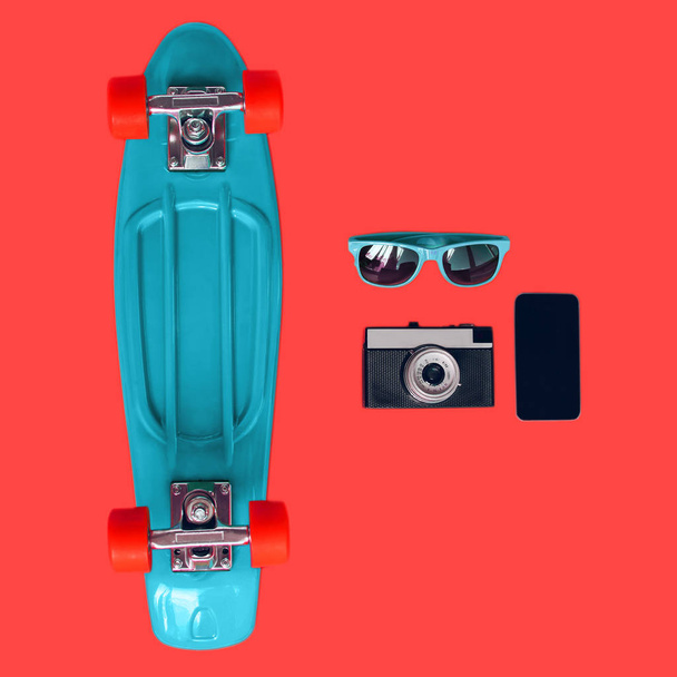 Colorful blue skateboard, sunglasses, vintage film camera and fr - Photo, image